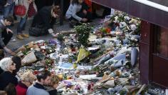 People place flowers outside Le Carillon restaurant, one of the attack sites in Paris