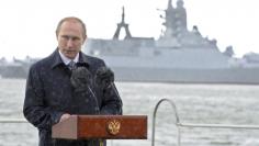 Russian President Vladimir Putin delivers a speech during celebrations for Navy Day as it rains in Baltiysk