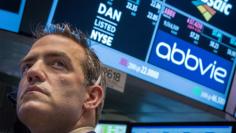 FILE PHOTO: A trader works by the post that trades AbbVie on the floor of the New York Stock Exchange March 5, 2015. REUTERS/Brendan McDermid 