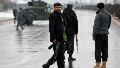 Afghan policemen keep watch near the site of an attack at the Marshal Fahim military academy in Kabul, Afghanistan