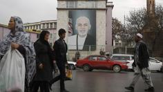 People walk past a picture of Afghan President Ashraf Ghani on a street in Kabul February 19, 2015. REUTERS/Omar Sobhani 