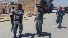 Afghan policemen keep watch near the site of a suicide bomb attack in Kabul