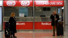 FILE PHOTO: A couple stand near an empty Niki customer care desk at Palma de Mallorca airport, Spain, December 14, 2017. REUTERS/Clara Margais