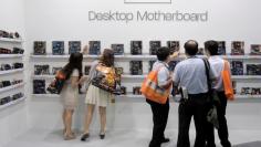 FILE PHOTO: Visitors look at motherboards being displayed at the AMD booth during the 2012 Computex exhibition at the TWTC Nangang exhibition hall in Taipei June 6, 2012. REUTERS/Yi-ting Chung/File Photo   