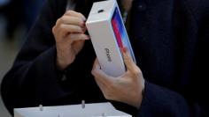 FILE PHOTO: A customer looks at her Apple iPhone X at an Apple store in New York, U.S., November 3, 2017.  REUTERS/Lucas Jackson/File Photo 