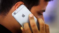 FILE PHOTO: A man talks on his iPhone at a mobile phone store in New Delhi, India, July 27, 2016. REUTERS/Adnan Abidi/File photo