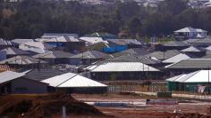 FILE PHOTO: A builder works atop a house under construction at a housing development located in the western Sydney suburb of Oran Park in Australia, October 21, 2017. REUTERS/David Gray