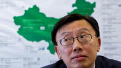 FILE PHOTO: Tsien, president of GM China, reacts in front of a map during an interview with Reuters at the company's headquarters in Shanghai