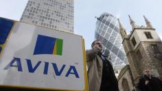 Pedestrians walk past an Aviva logo outside the company's head office in the city of London March 5, 2009. REUTERS/Stephen Hird