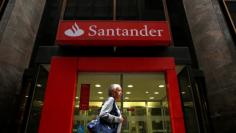 FILE PHOTO: A woman walks past a Banco Santander branch in downtown Rio de Janeiro August 19, 2014.   REUTERS/Pilar Olivares/File Photo           