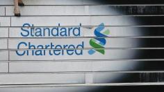 A woman walks down the stairs of the Standard Chartered headquarters in Hong Kong in this October 13, 2010 file photo.  REUTERS/Bobby Yip/Files  