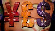 The dollar sign is seen alongside the signs for other currencies above a currency exchange shop in Mongkok shopping district in Hong Kong