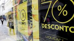 People walk past a store with signboards offering 70% off on store products in downtown Sao Paulo, Brazil January 9, 2018. REUTERS/Paulo Whitaker