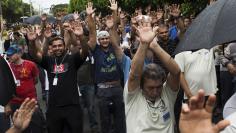 Employees of Embraer's main aircraft factory raise their hands outside their workplace during a pay-rise strike in Sao Jose dos Campos November 5, 2014. REUTERS/Roosevelt Cassio 