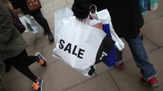 A shopper carries a bag advertising a sale on Oxford Street in London, Britain December 26, 2015.  REUTERS/Neil Hall 