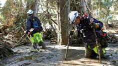 Firefighters Brandon Bennewate (R), and Billy Wren dig through mud searching for bodies after mudslides in southern California left officials searching for the missing, damaged hundreds of buildings and caked highways with sludge, in Montecito. REUTERS/D