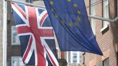 The Union Flag flies next to the European Flag outside the European Commission building in central London