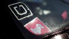 File photo of a  driver displaying Uber and Lyft ride sharing signs on his car windscreen in Santa Monica