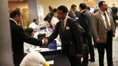A job seeker (R) meets with a prospective employer at a career fair in New York City, October 24, 2012.   REUTERS/Mike Segar 