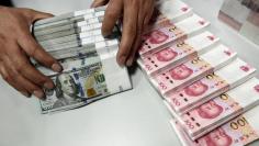 A clerk counts Chinese yuan and U.S. dollar banknotes at a branch of Bank of China in Taiyuan, Shanxi province, China, January 4, 2016. REUTERS/Jon Woo 