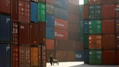 FILE PHOTO -  A woman walks past containers at a port in Shanghai January 13, 2009.   REUTERS/Aly Song/File Photo   