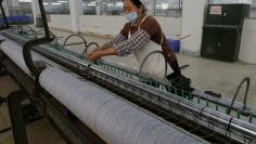 FILE PHOTO: A worker disentangles wool yarn at a spinning machine at a factory owned by Hong Kong's Novetex Textiles Limited in Zhuhai City, Guangdong Province, China December 13, 2016.  REUTERS/Venus Wu/File Photo