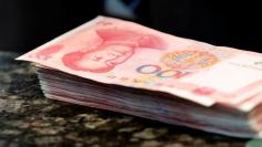 Chinese 100 yuan banknotes are seen on a counter of a branch of a commercial bank in Beijing