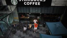 Customers walk out of a Starbucks coffee store in Shanghai in this July 28, 2014 file photo. REUTERS/ Carlos Barria  