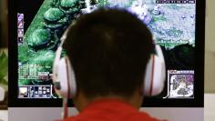 A man plays a computer game at an internet cafe in Beijing May 9, 2014. REUTERS/Kim Kyung-Hoon