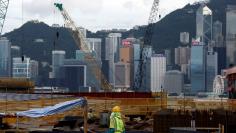 FILE PHOTO:  A worker stands on a construction site as part of the West Kowloon Terminus project for the Guangzhou-Shenzhen-Hong Kong Express Rail Link in Hong Kong