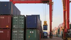 A container box is loaded on to a truck at a port in Rizhao, Shandong province, August 12, 2015. REUTERS/Stringer