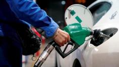 A gas station attendant pumps fuel into a customer's car at a gas station in Shanghai, China November 17, 2017. REUTERS/Aly Song