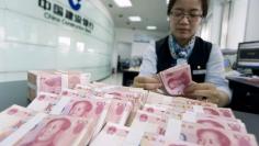 A clerk counts Chinese 100 yuan banknotes at a branch of China Construction Bank in Hai'an, Jiangsu province June 10, 2014. REUTERS/China Daily 