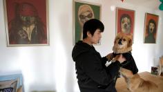 Pet dog Rourou waits for its lunch on a table in a restaurant at Cute Beast Pet Resort in Beijing