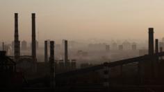 Chimneys and cooling towers of a steel plant are seen through the fog in Beijing