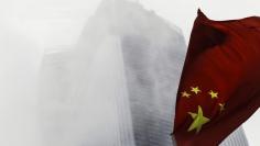 A Chinese national flag flutters in front of a construction site in Guangzhou, Guangdong province, November 7, 2014. REUTERS/Alex Lee 