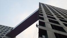 A worker cleans an apartment block in Beijing, October 18, 2014. Growth in China's residential land prices slowed for the second straight quarter in July-September, the land ministry said, underlining cooling momentum in the property market. . REUTERS/Jas