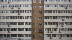 FILE PHOTO: A man riding a bicycle drives past an apartment building in Beijing, March 18, 2015. REUTERS/Kim Kyung-Hoon 