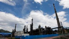 FILE PHOTO: A security personnel stands guard at the Yanshan oil refinery of Sinopec Corp. in Beijing