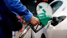 FILE PHOTO: A gas station attendant pumps fuel into a customer's car at a gas station in Shangha