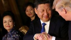 FILE PHOTO: Chinese President Xi Jinping shakes hands with U.S. President Donald Trump as he is accompanied by China's first lady Peng Liyuan during a dinner at the start of a summit between President Trump and President Xi at Trump's Mar-a-Lago estate i