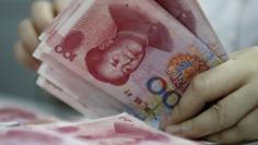 An employee counts yuan banknotes at a bank in Huaibei, Anhui province June 22, 2010. REUTERS/Stringer 