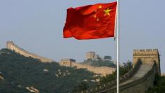 A Chinese flag flies in front of the Great Wall of China, located north of Beijing August 18, 2007.      REUTERS/David Gray  