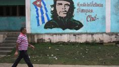 A man walks past near an image of revolutionary hero Ernesto "Che" Guevara in Havana December 27, 2014.   REUTERS/Stringer 