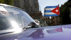 A Cuban flag flies attached on a vintage car in Havana September 18, 2015. REUTERS/Carlos Garcia Rawlins