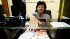 Woman exchanges forints for euros at currency exchange shop in Esztergom