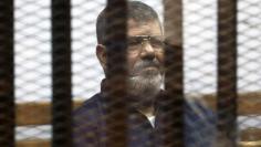 File photo of deposed Egyptian President Mursi listening to his verdict behind bars at a court on the outskirts of Cairo