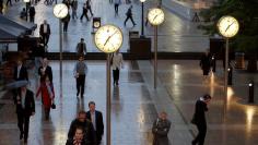 FILE PHOTO: Workers walk through the Canary Wharf financial district of London