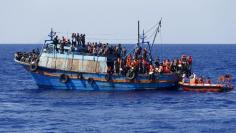 FILE PHOTO - Migrants on board an overloaded wooden boat are rescued some 10.5 miles (16 km) off the coast of Libya August 6, 2015.  REUTERS/Darrin Zammit Lupi