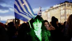 A woman holds a Greek flag as she takes part in an anti-austerity pro-government demonstration in front of the parliament in Athens February 11, 2015. REUTERS/Yannis Behrakis 